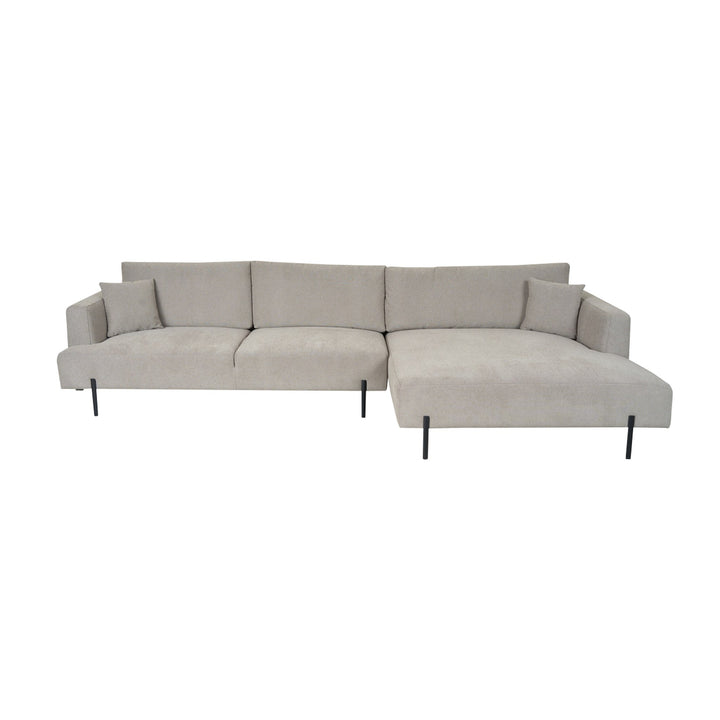 Milazzo hjørnesofa i lys beige stoff med høyrevendt sjeselong, slanke sorte metallben og pynteputer mot hvit bakgrunn