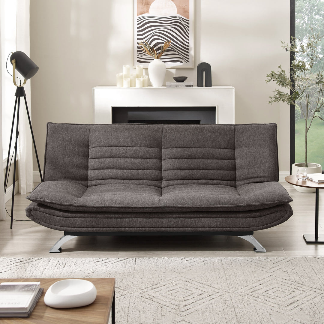 Friday sovesofa i mørk grå i stue med gulvlampe, peis og grønn plante