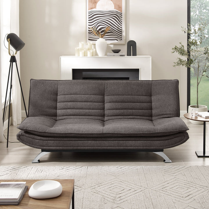 Friday sovesofa i mørk grå i stue med gulvlampe, peis og grønn plante