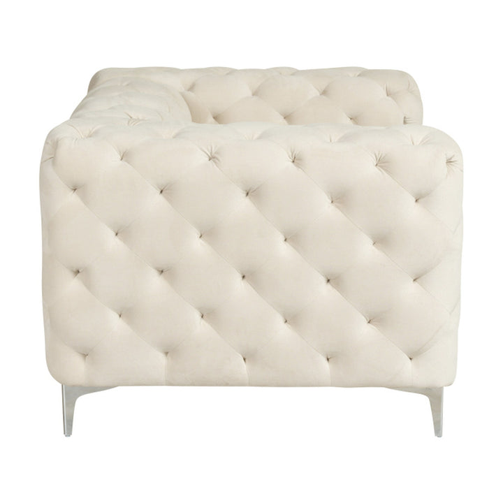 Bella sofa i kremhvit velur, dyptuftet chesterfield-lenestol sett fra siden