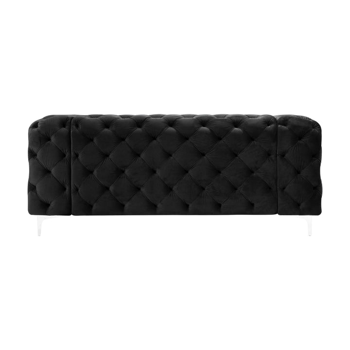 Bella sofa i sort tuftet velur med blanke akrylben, sett forfra mot hvit bakgrunn.