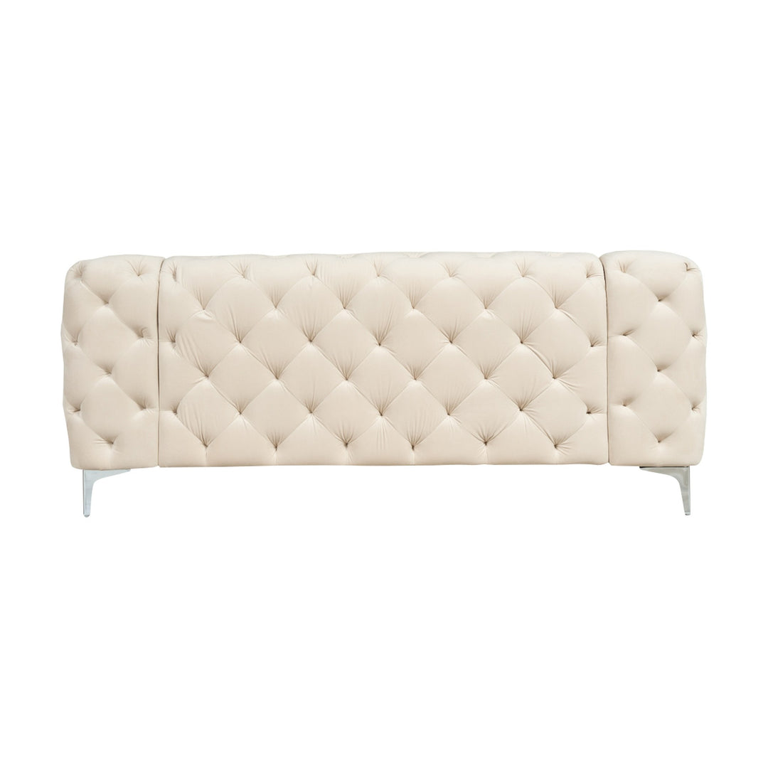 Bella sofa i kremhvit tuftet velur med krombein, sett forfra mot hvit bakgrunn.