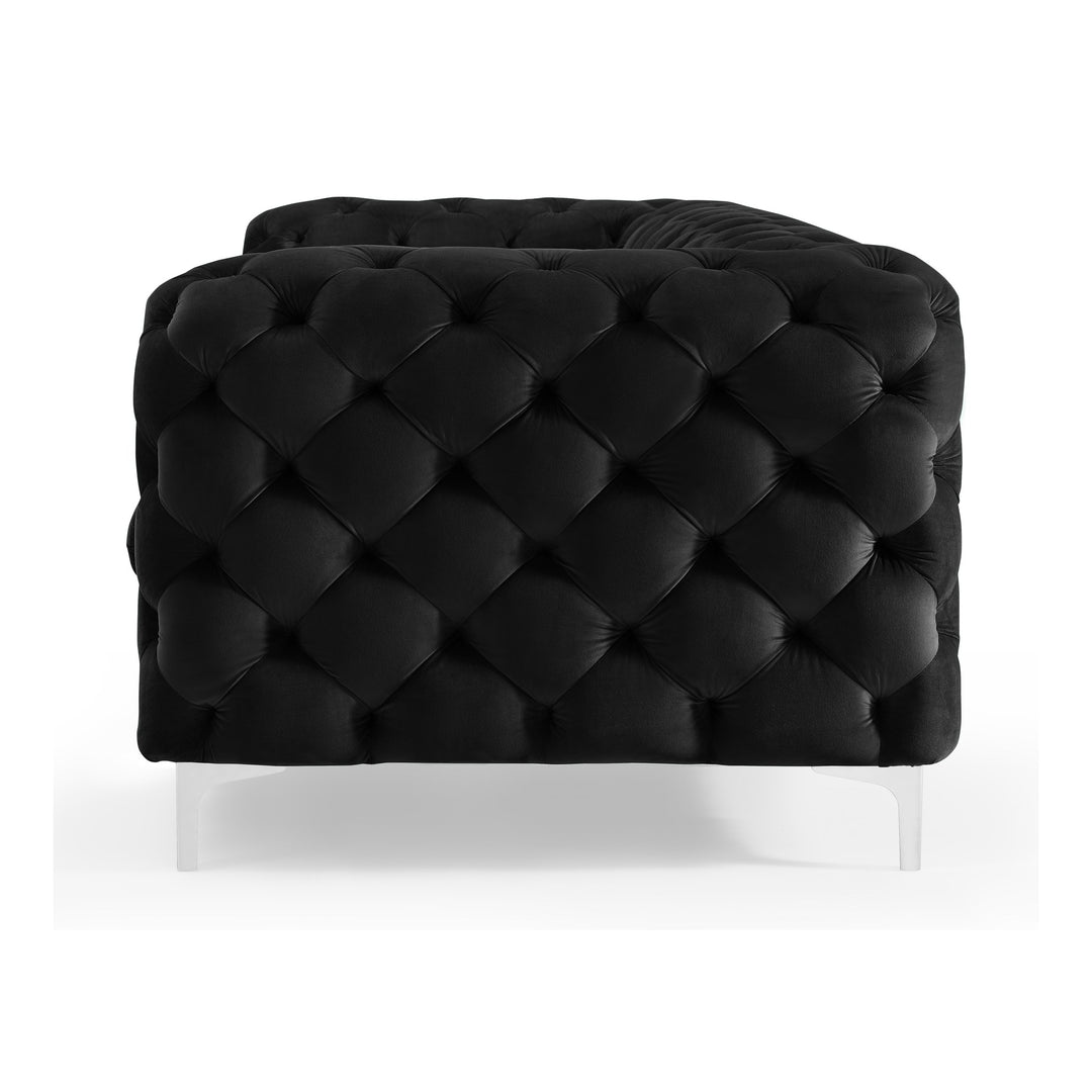 Bella sofa i sort tuftet velur med blanke akrylben, sett fra siden mot hvit bakgrunn.