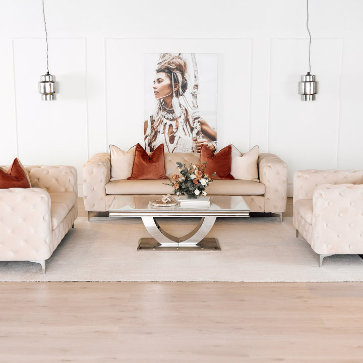 Bella sofa og stoler i kremhvit velur med knappet chesterfield-design, rustrøde puter og speilbord