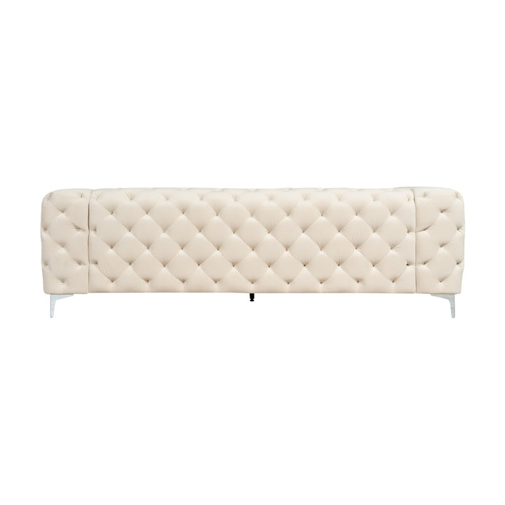 Bella sofa i kremhvit tuftet velur med krombein, sett forfra mot hvit bakgrunn.