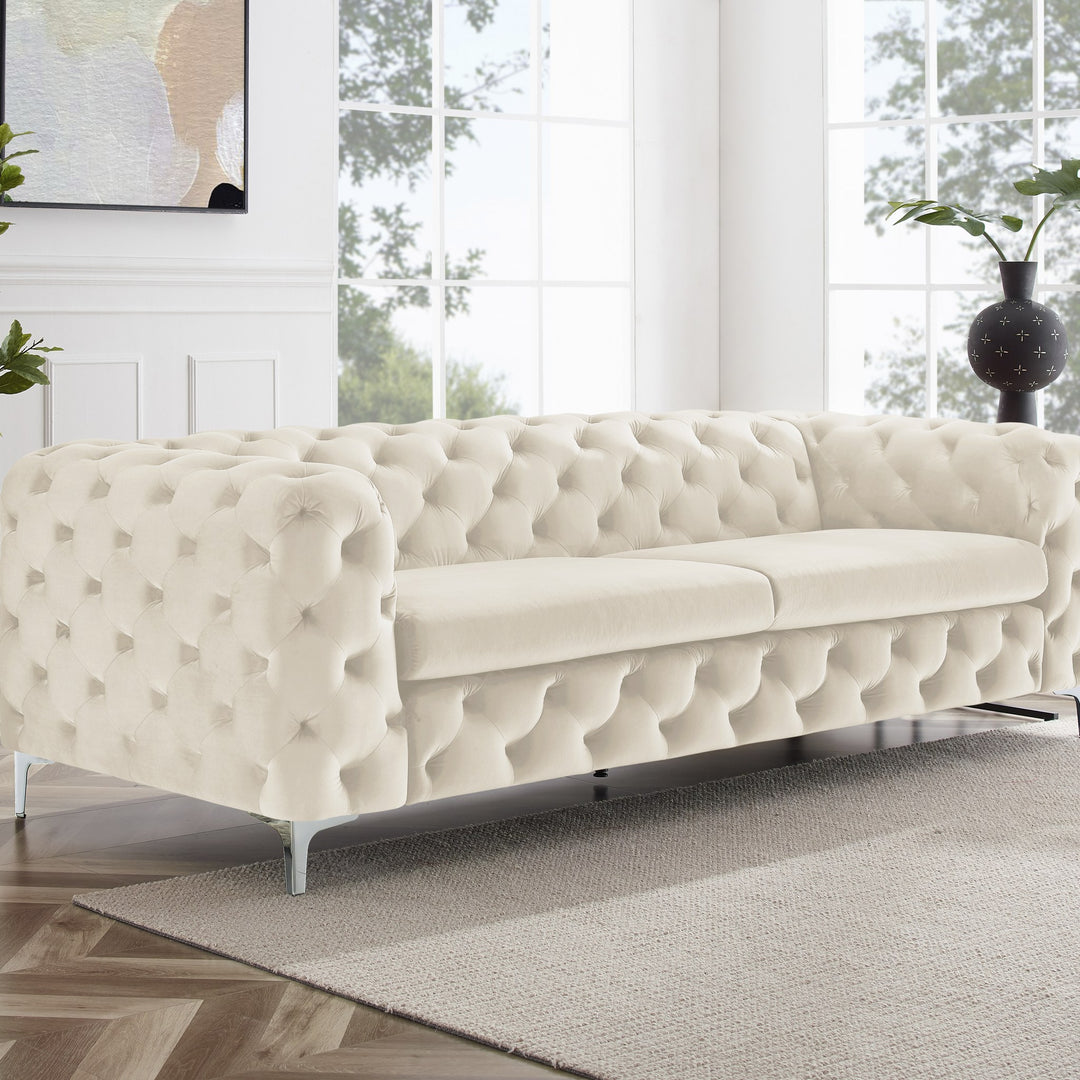 Bella sofa i krem velur, treseter i lyst rom med fiskebensparkett, plante og veggbilde