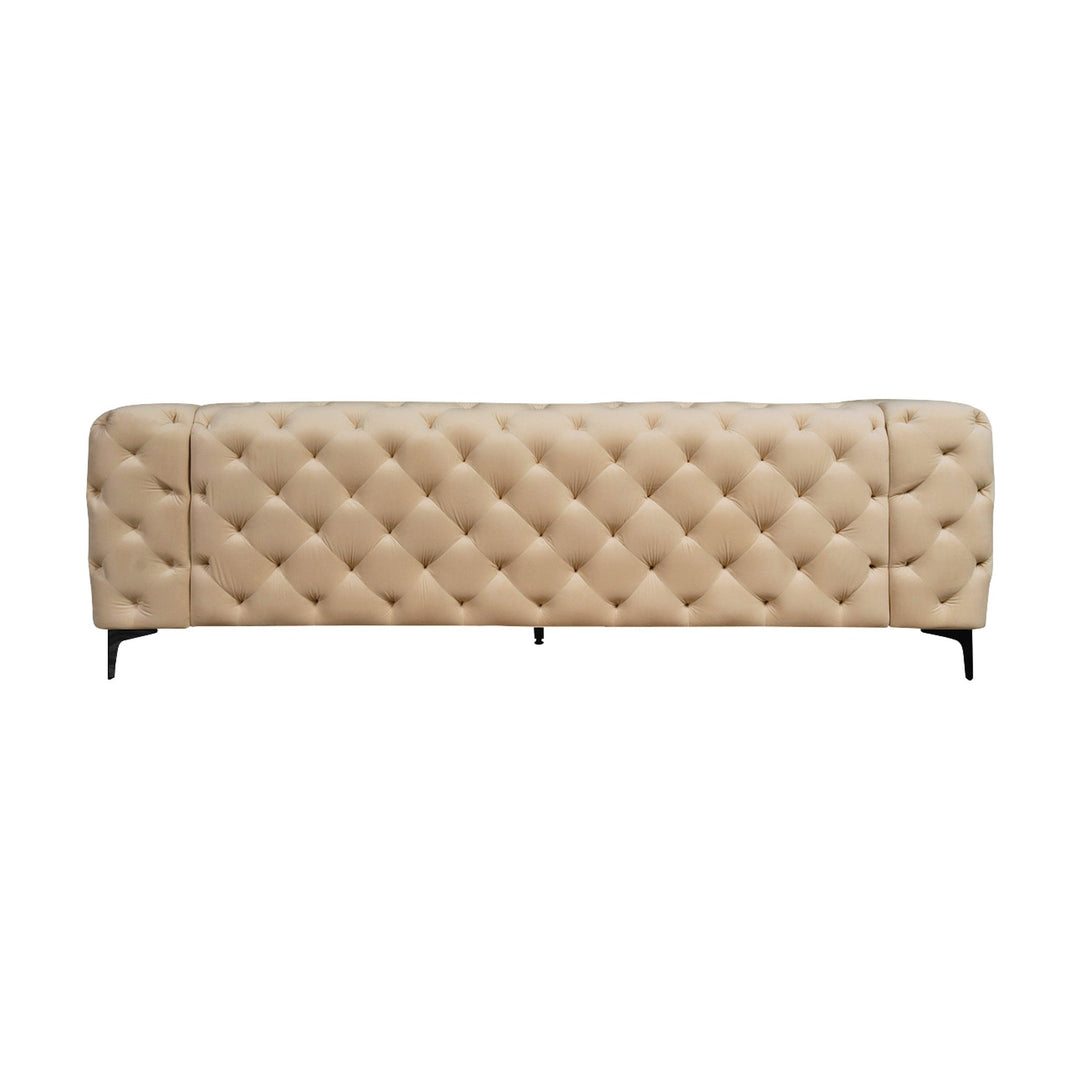 Bella sofa i beige tuftet velur med sorte ben, sett forfra mot hvit bakgrunn.