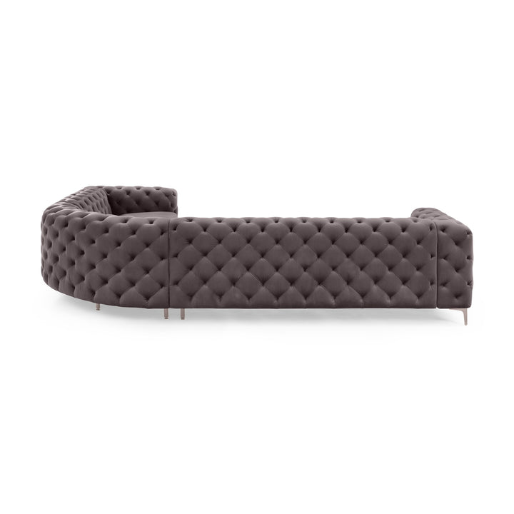 Bella buet sofa i grå tuftet velur med metallben, sett fra siden mot hvit bakgrunn.