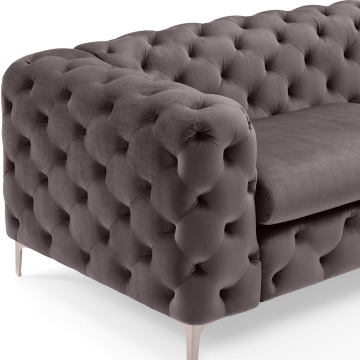Bella sofa i grå tuftet velur, nærbilde av armlene med kobberfarget metallben.