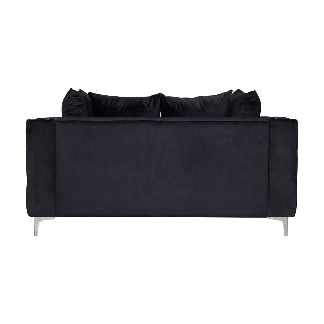 Dallas sofa i sort velur med puter, sett bakfra mot hvit bakgrunn.
