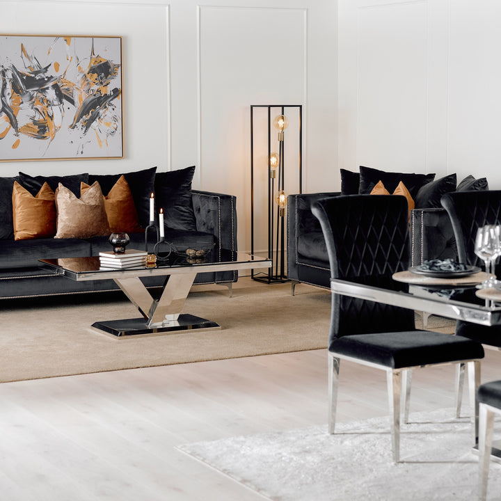 Dallas sofa i sort velur, stilig stue med speilbord, gulvlampe og brune aksentputer