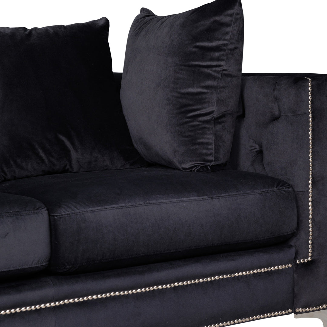 Dallas sofa i sort velur, nærbilde av hjørne med pute og sølvnaglekant