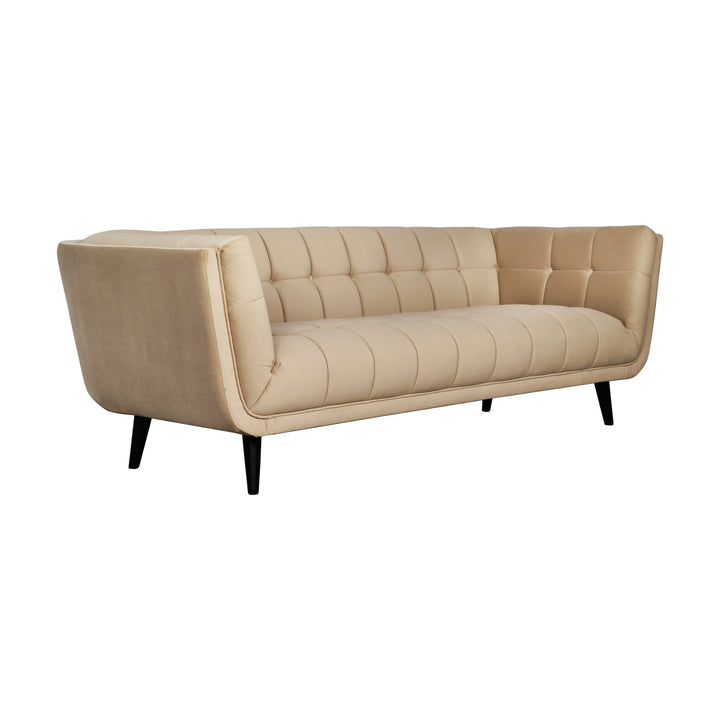 Simon sofa i beige velur, 3-seter med rutetufting og svarte ben, sett skrått forfra.