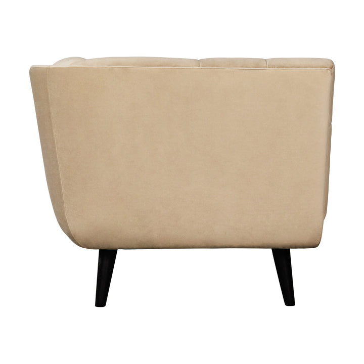 Simon sofa i beige velur, sidevisning av toseter med svarte spisse trebein