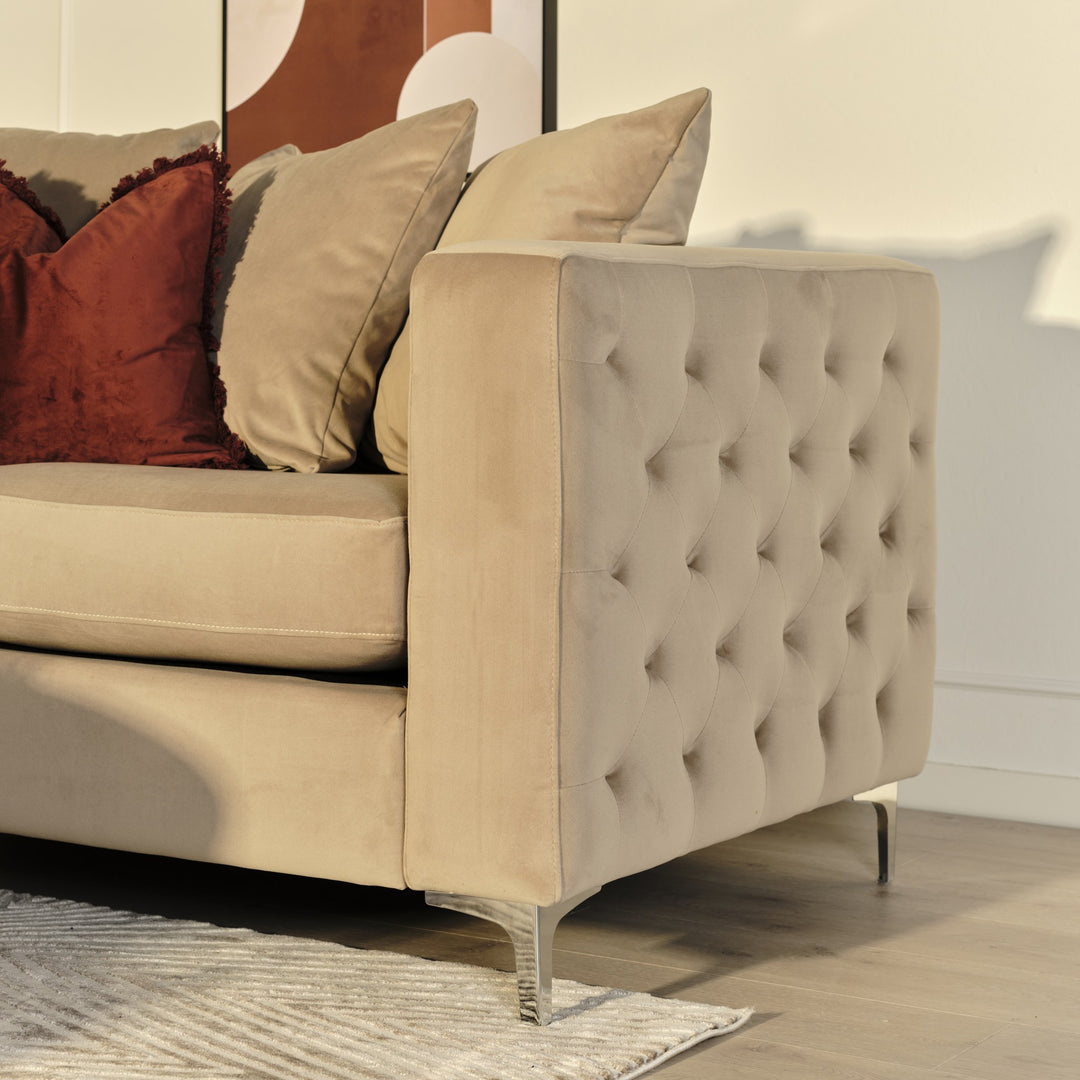 Boston sofa i beige velur i stuemiljø, med rustrøde og beige puter og krombein.