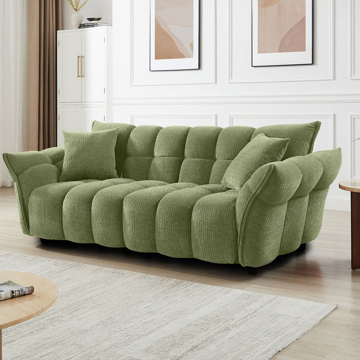 Marigold sofa i grønn kordfløyel, lang firseter i lyst stuemiljø med veggbilder