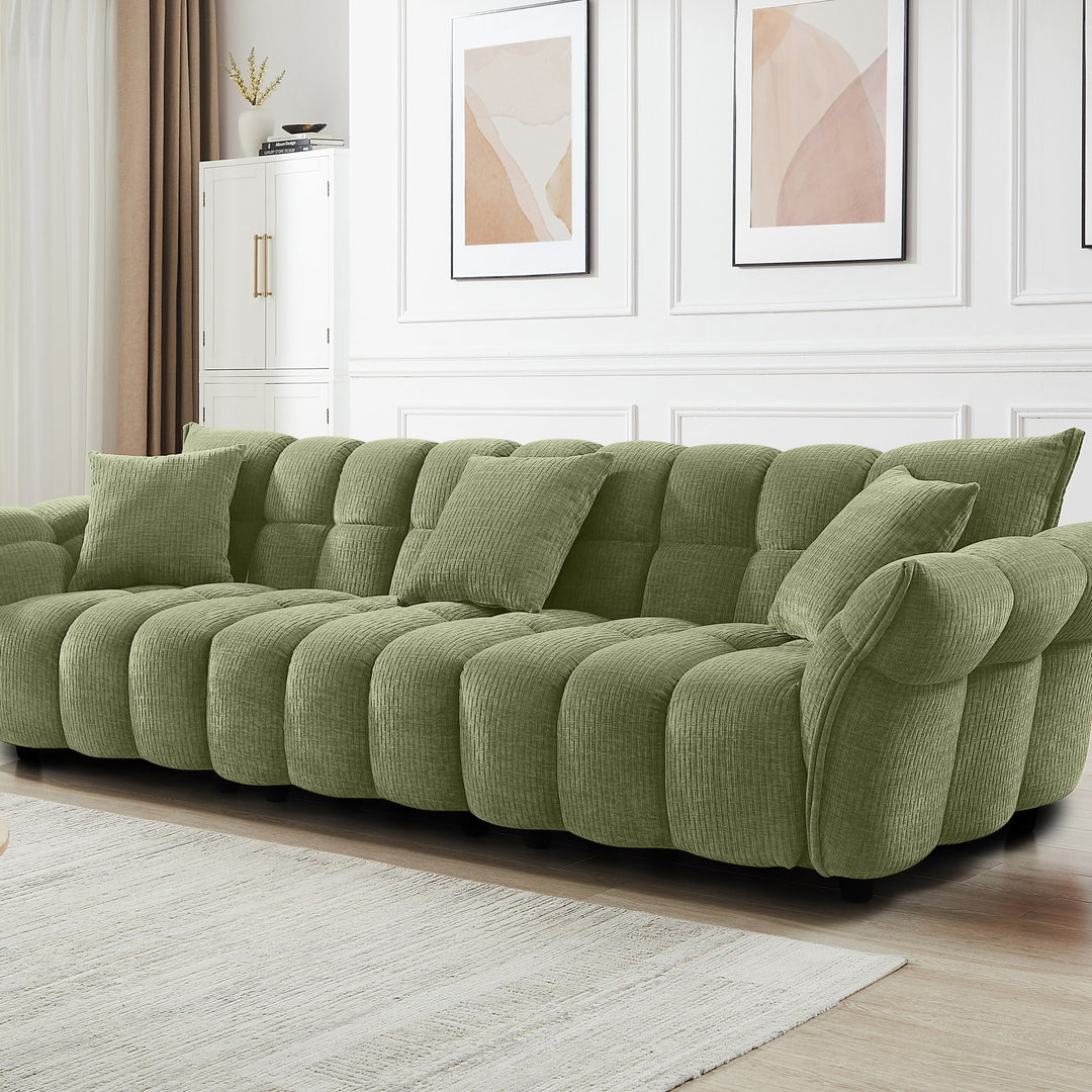 Marigold sofa i grønn kordfløyel i lyst stuemiljø, skråvisning med pløsede puter