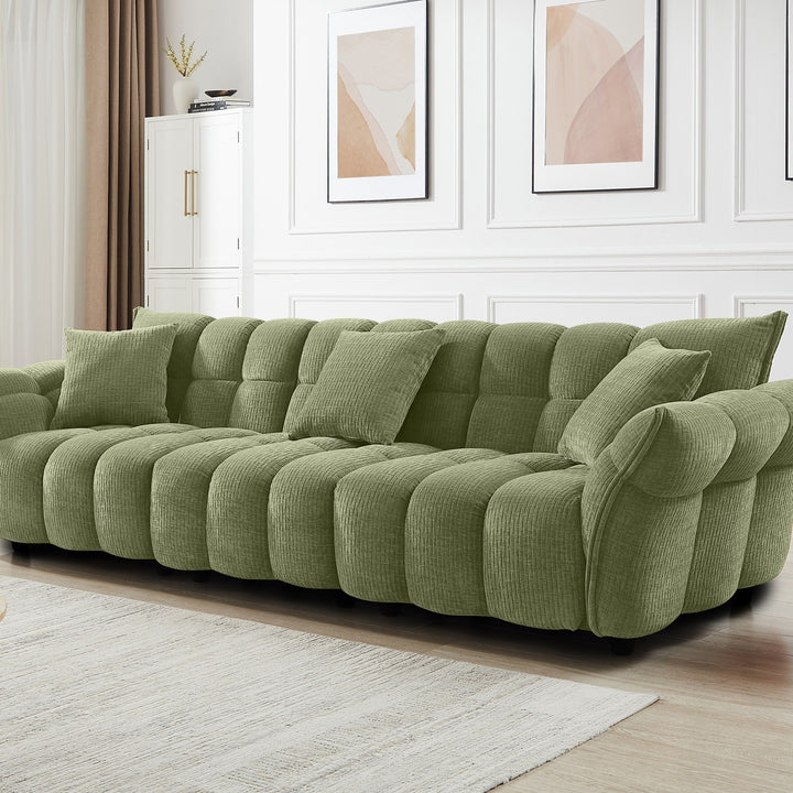 Marigold sofa i grønn kordfløyel i lyst stuemiljø, skråvisning med pløsede puter