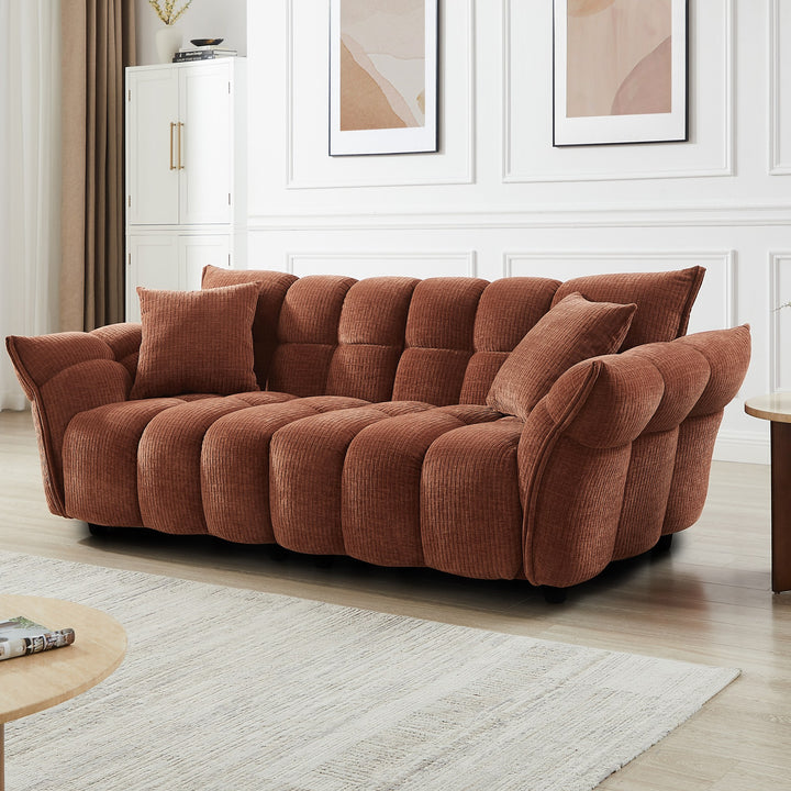 Marigold sofa i terrakotta kordfløyel, lang firseter i lyst stuemiljø med veggbilder