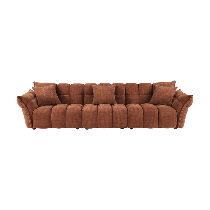 Marigold sofa i rust med puffet, ribbet chenillestoff og mørke ben