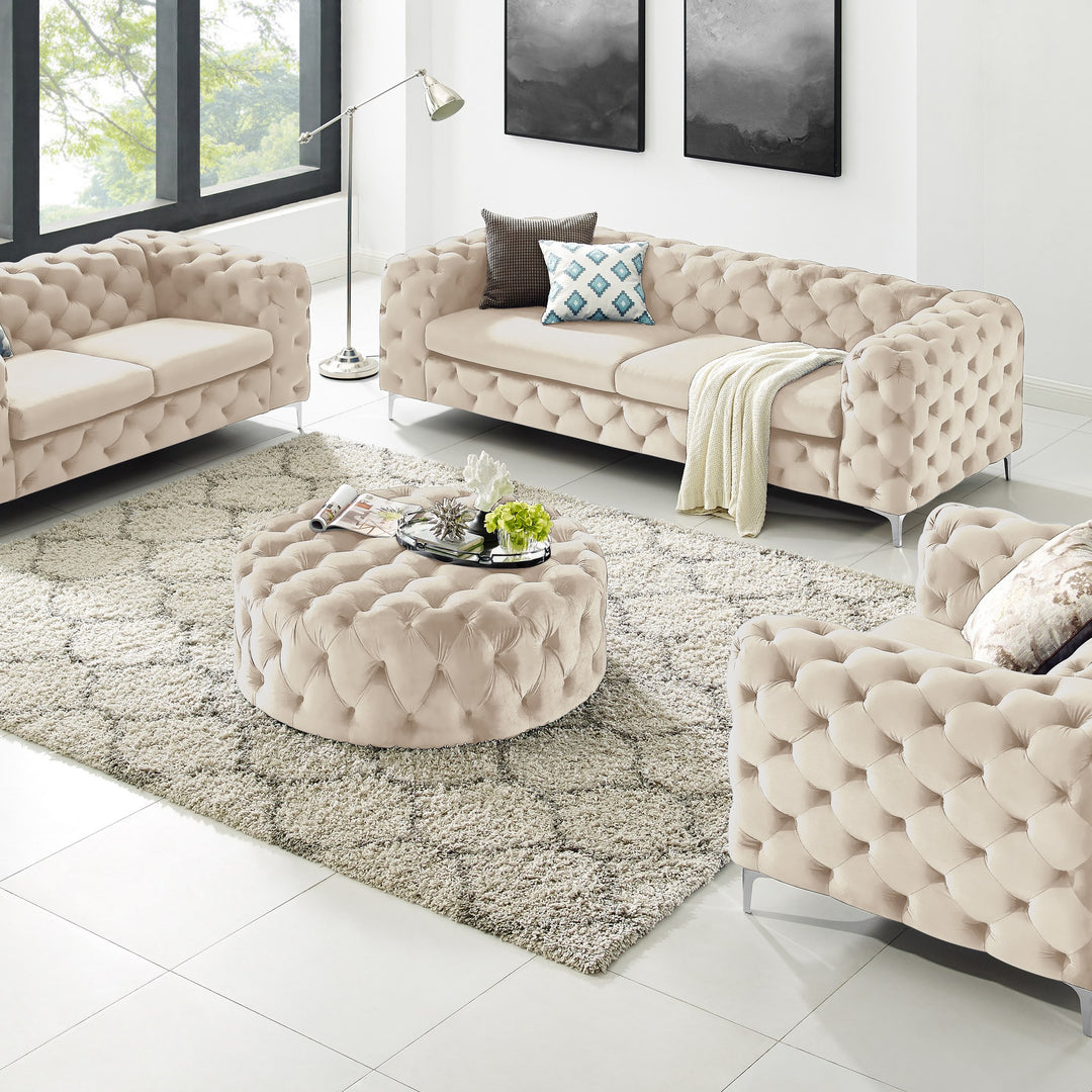 Bella puff i beige velur med knappetufting, rund modell i stue med chesterfieldsofaer