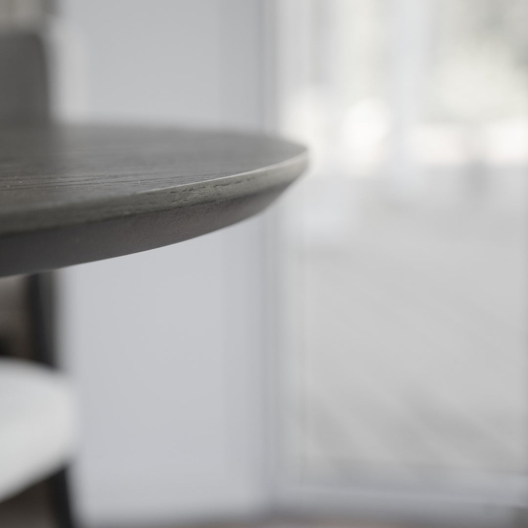Rowico Calverton spisebord, nærbilde av rund bordplatekant i mørk eik mot lyst vindu.