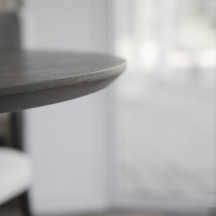 Rowico Calverton spisebord, nærbilde av rund bordplatekant i mørk eik mot lyst vindu.