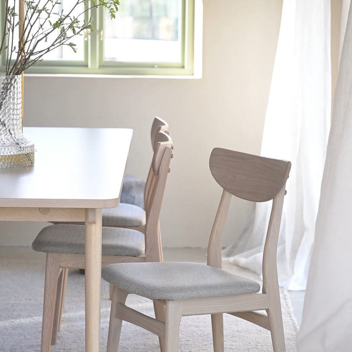 Rowico Rodham spisestol i lys eik med gråbeige sete ved spisebord i lyst rom