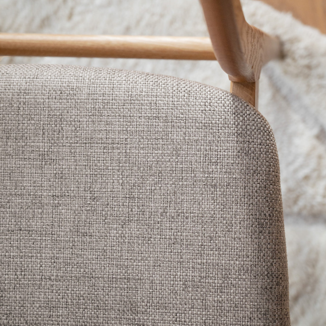 Rowico Rodham spisestol i eik, nærbilde av gråbeige vevd rygg- og setetrekk med saueskinn bak