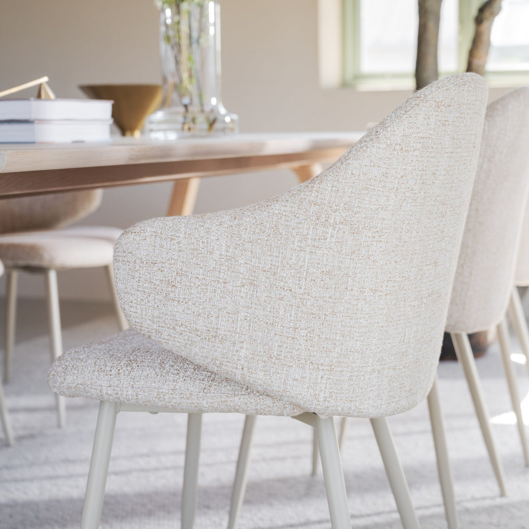Rowico Drake spisestoler i beige bouclé ved lyst eikebord i spiserom