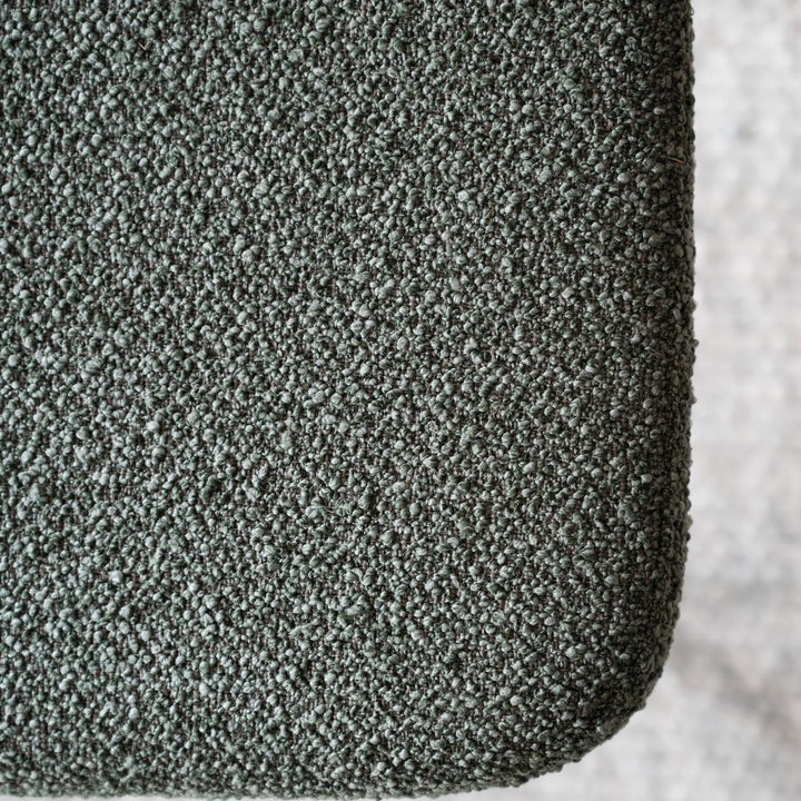 Rowico Herbster spisestol, nærbilde av grågrønn bouclé-stoff mot betongbakgrunn
