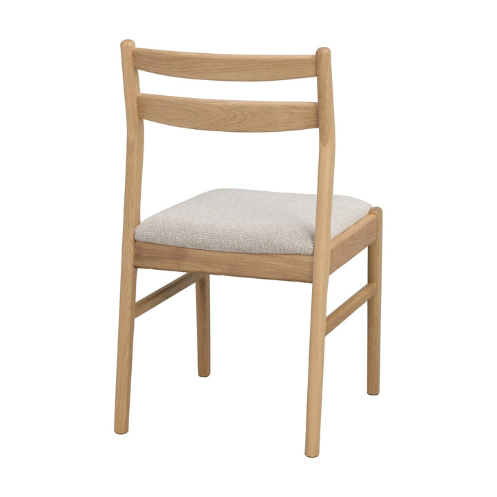 Rowico Kerwin spisestol i lys eik med gråbeige stoffsete, sett skrått bakfra mot hvit bakgrunn