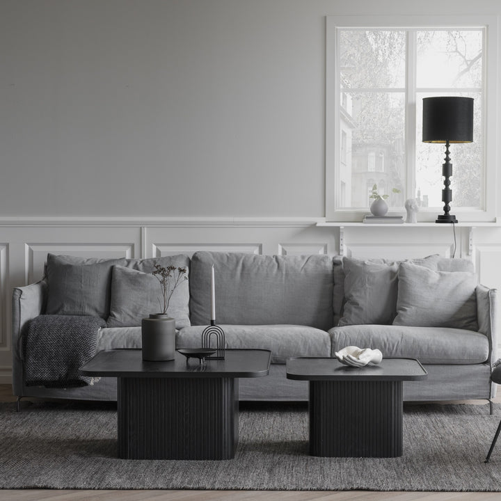 Rowico Sullivan sofabord i sort eik med riflet sokkel, i grå stue med sofa og svart bordlampe