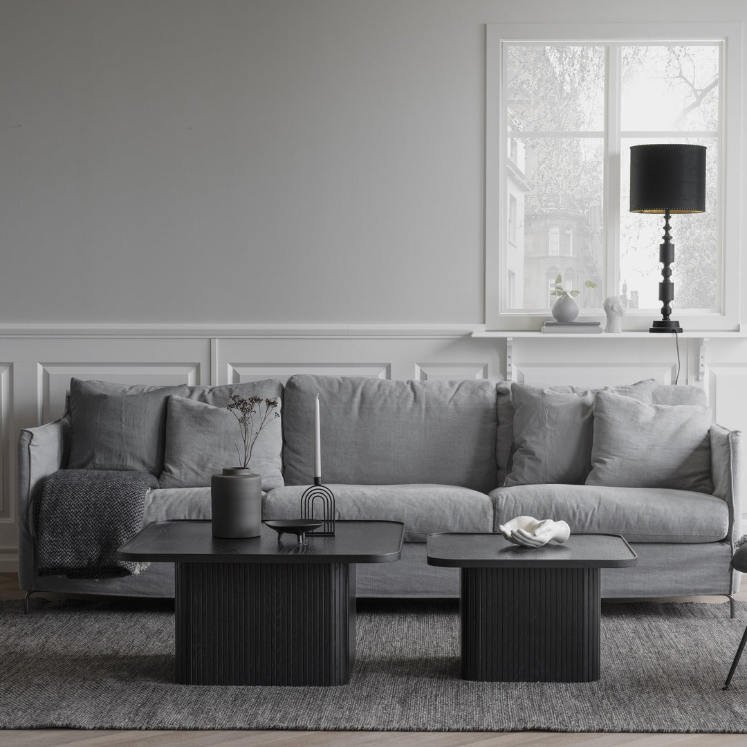 Rowico Sullivan sofabord i sort eik med riflet sokkel, i grå stue med sofa og svart bordlampe