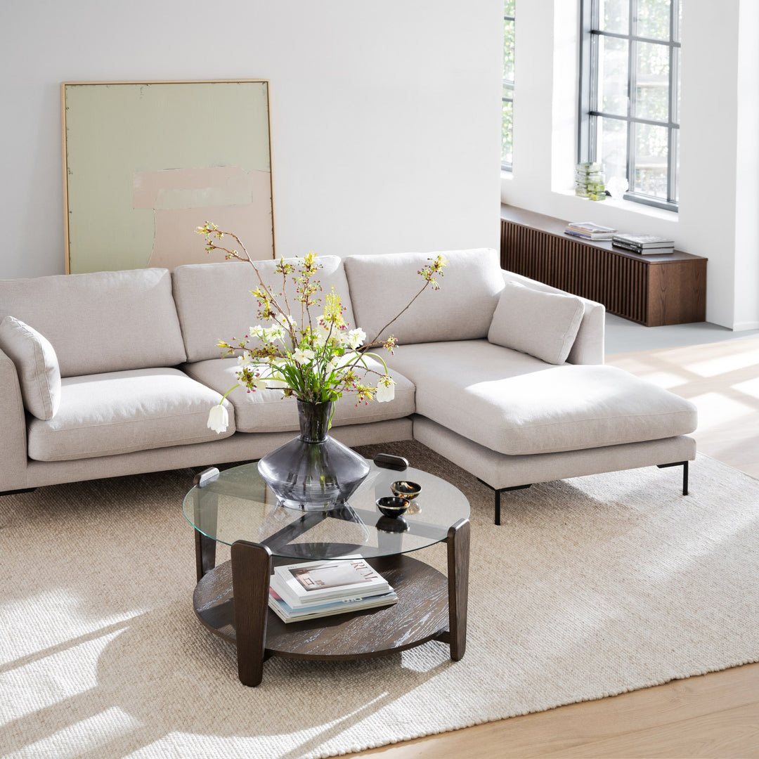 Rowico Arran sofabord i mørk brun eik med glassplate, i lys stue med beige sofa og vase med blomster