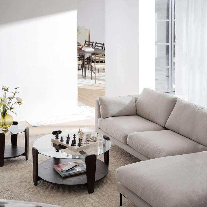 Rowico Arran sofabord med glassplate og mørk eik, sjakkspill på toppen, ved siden av lys beige sofa i stue