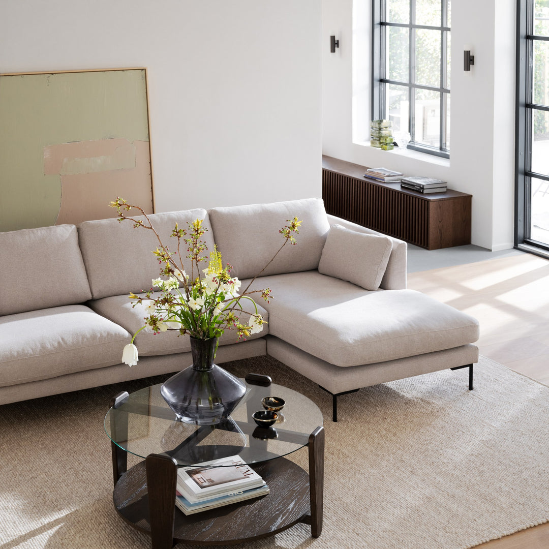 Rowico Arran sofabord i brun eik med glasstopp, ved beige hjørnesofa i lys stue med kunst
