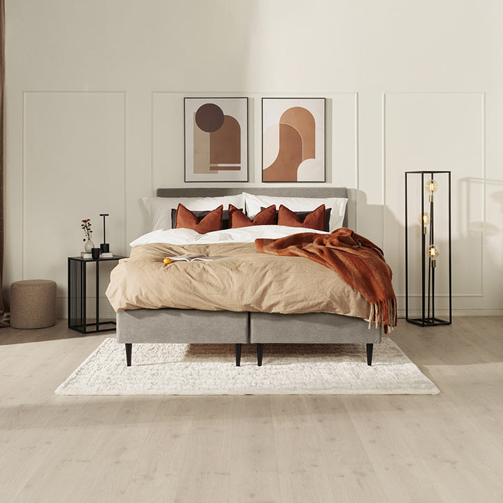 Asleep Venus sengegavl i grå stoff i lyst soverom med beige sengetøy og rustfarget pledd