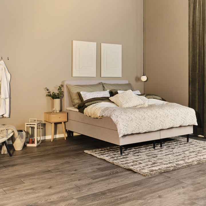 Remmen Alfred nattbord i lys eik ved beige kontinentalseng i lyst soverom