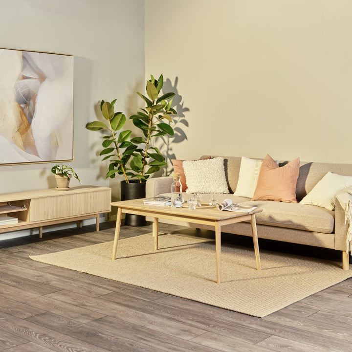 Orust sofabord i lys eik i stue med beige sofa, grønne planter og jutematte