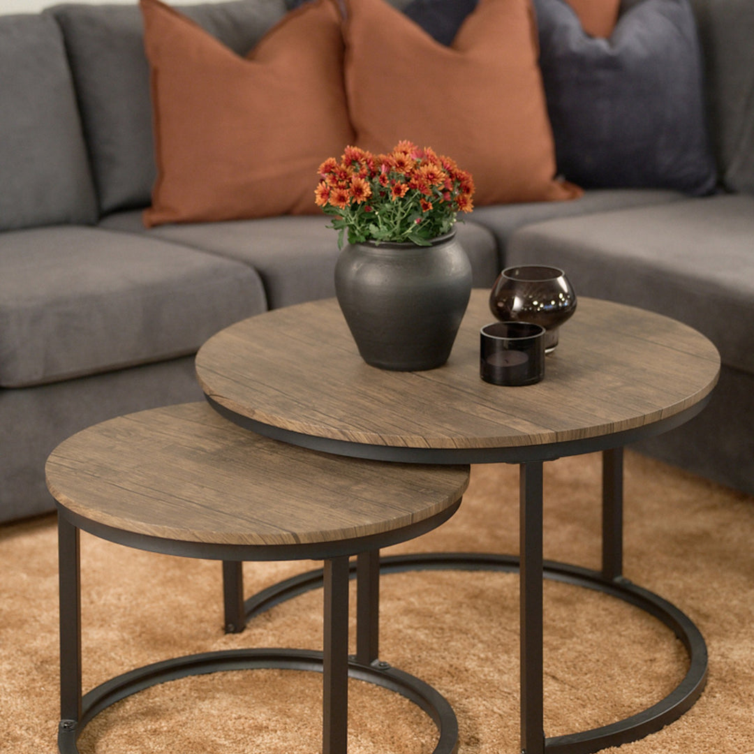 Hastings sofabord, to runde bord med trelook plate og sort metallramme, foran grå sofa