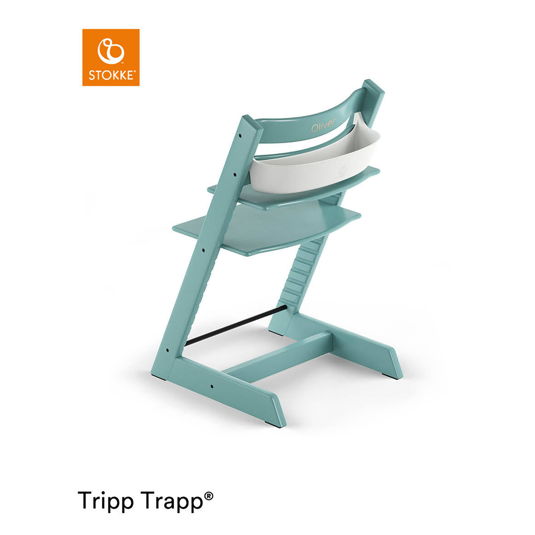 Stokke Tripp Trapp Storage, hvit oppbevaringsboks montert på aqua-blå høystol, sett bakfra