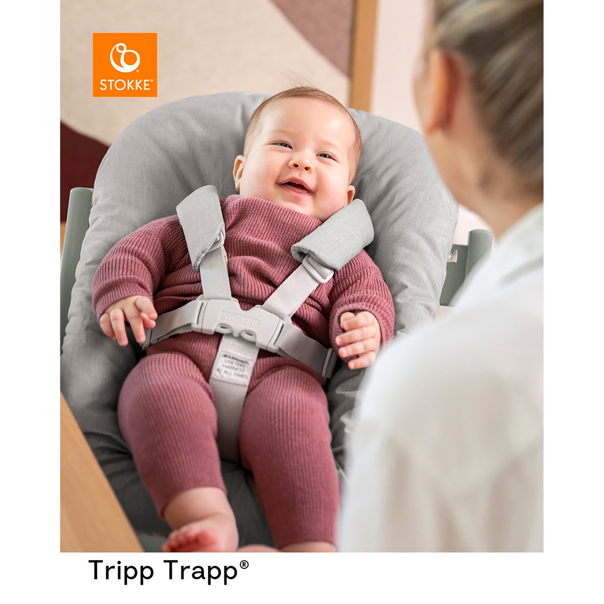Stokke Tripp Trapp Newborn Set i grått med smilende baby i selen, og voksen ved siden