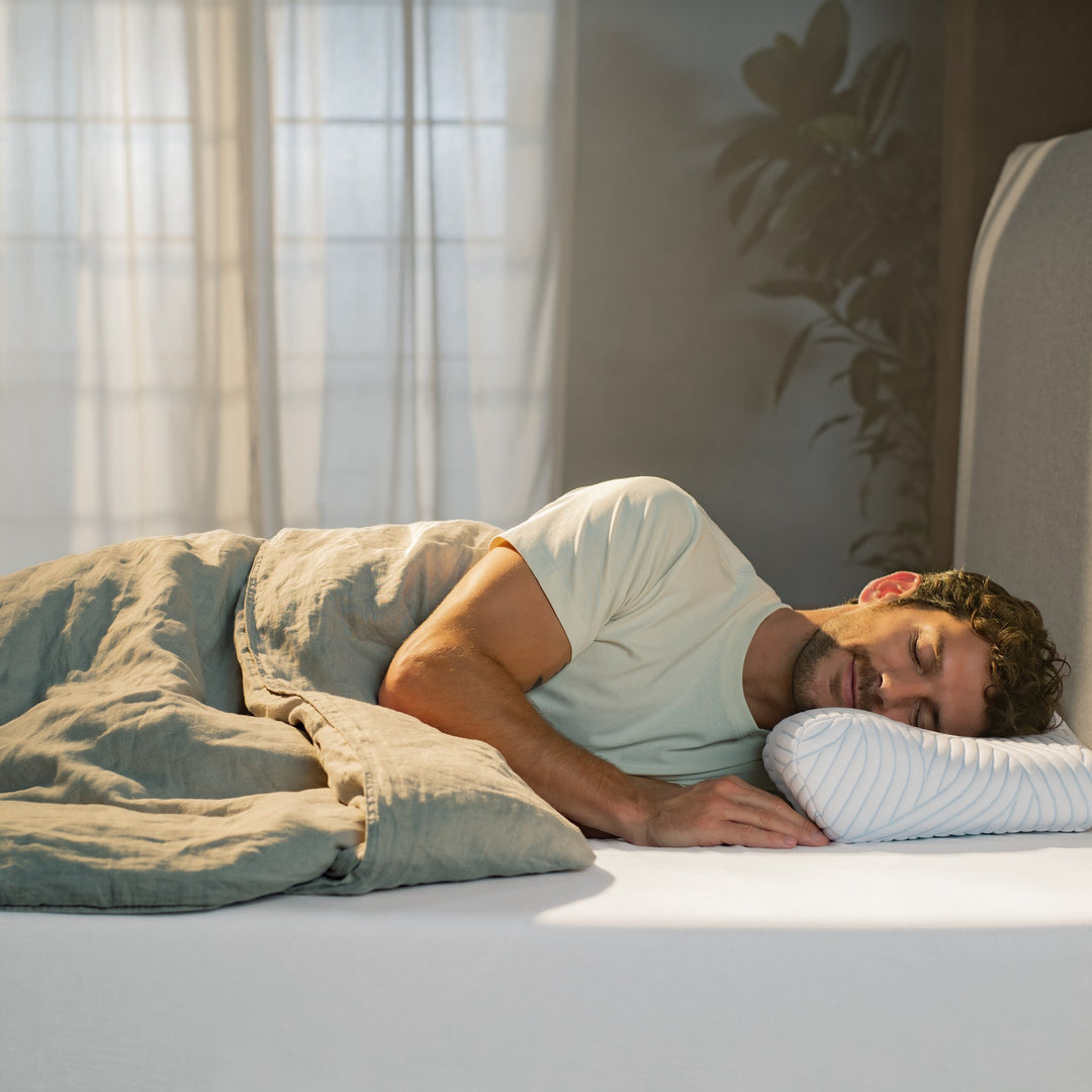 Tempur ErgoPlus SmartCool hodepute under sovende mann i mintgrønn t-skjorte i solfylt soverom