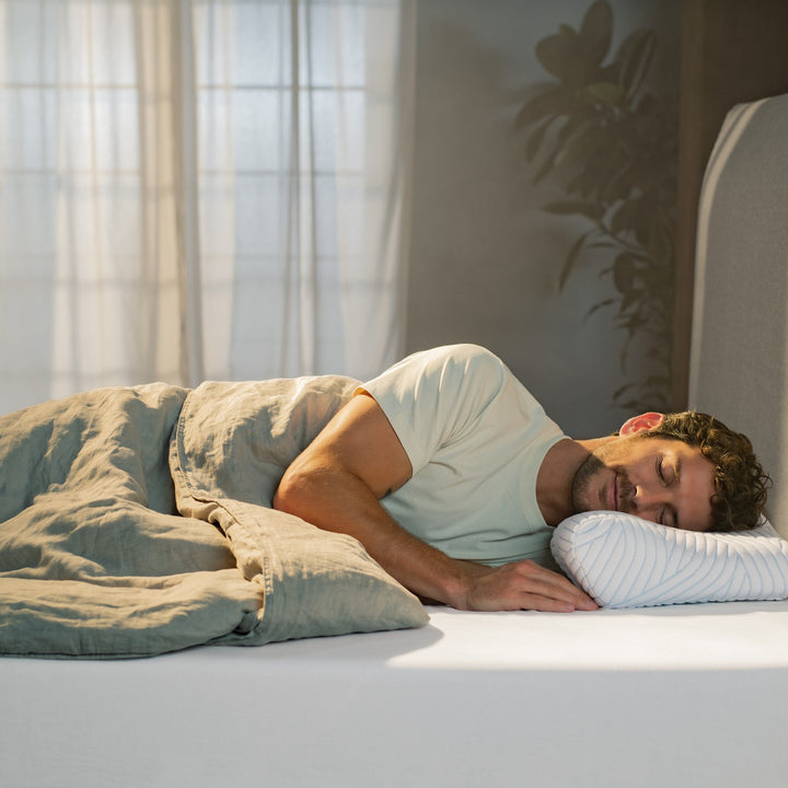 Tempur ErgoPlus SmartCool hodepute under sovende mann i mintgrønn t-skjorte i solfylt soverom