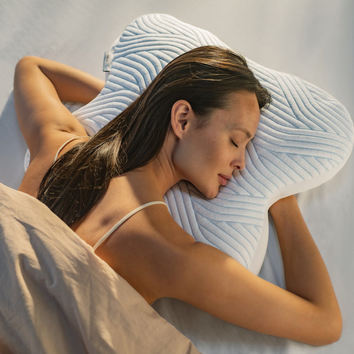 Tempur SmartCool Ombracio hodepute med buet fasong, sett ovenfra mens kvinne ligger med hodet i puten
