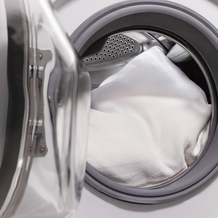 Tempur Comfort PureClean hodeputetrekk i hvitt lagt inn i en åpen vaskemaskin