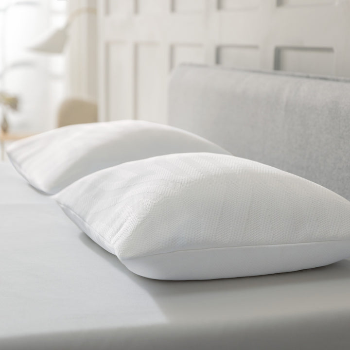 Tempur Comfort PureClean hodepute, to myke hvite puter på seng med grå sengegavl