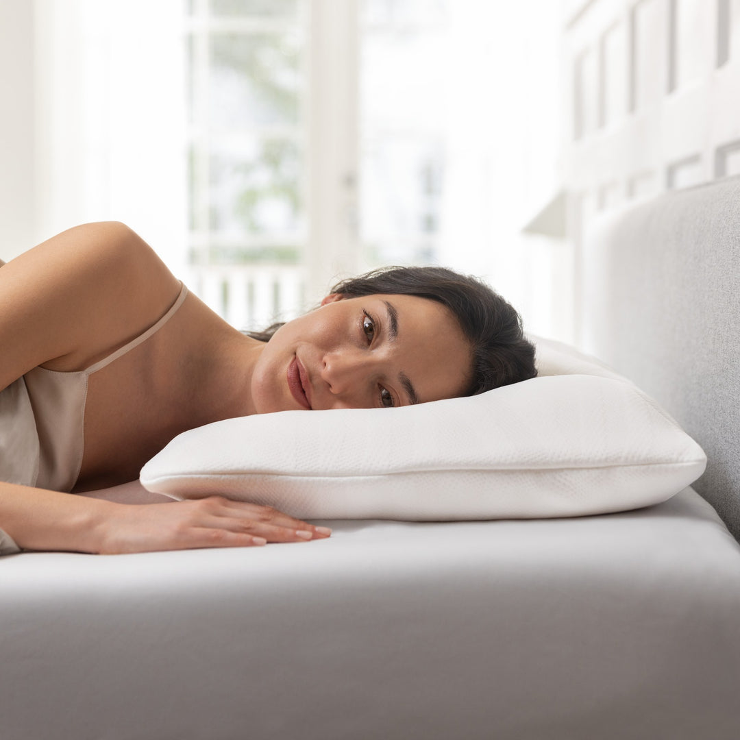 Tempur Comfort PureClean hodepute i hvitt under hodet til kvinne som ligger i lyst soverom