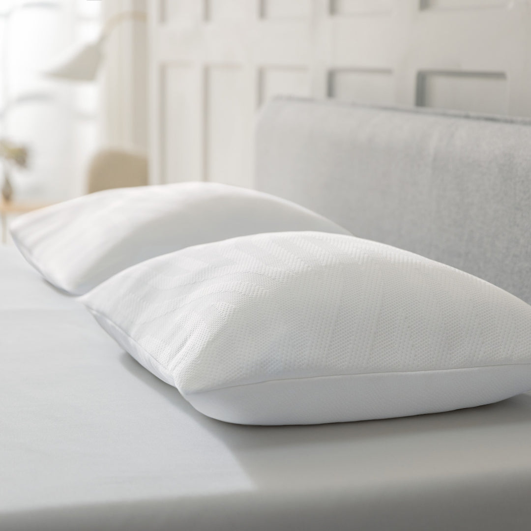 Tempur Comfort PureClean hodepute i hvitt, to puter på seng med grå gavl i lyst soverom